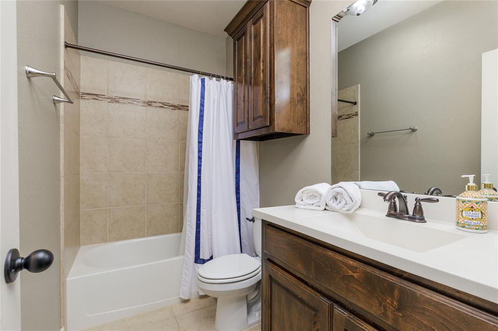 2205 State Boulevard McKinney, TX 75071 - Photo 21 of 40 Bathroom with vanity, shower / tub combo with curtain, and light tile patterned flooring