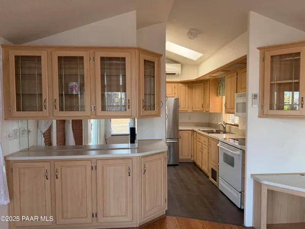 a kitchen with kitchen island granite countertop white cabinets and white appliances