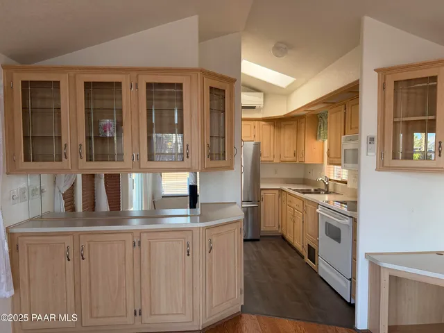 a kitchen with kitchen island granite countertop white cabinets and white appliances
