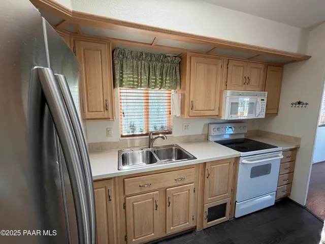 a kitchen with a sink a refrigerator and cabinets