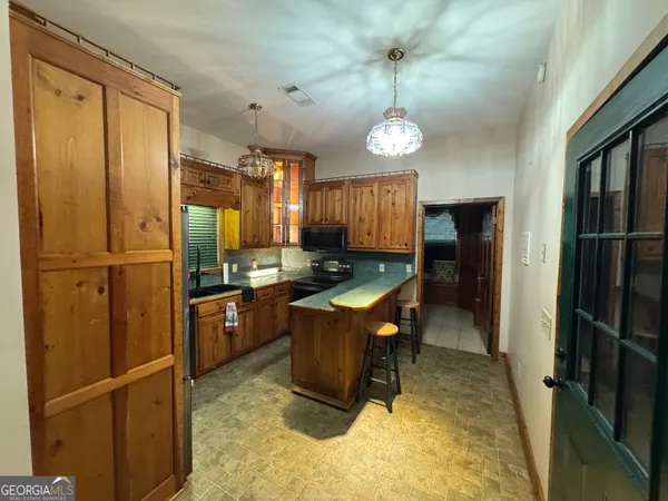 a room with stainless steel appliances kitchen island granite countertop furniture a refrigerator and a stove top oven