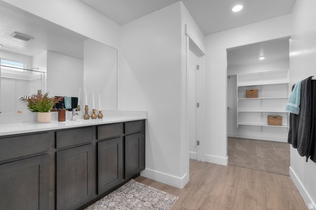 2819 South 710th West, Unit 14 Logan, UT 84321 - Photo 18 of 24 Vanity featuring dark wood-finish cabinetry, a light-toned countertop, and an integrated sink with a chrome faucet