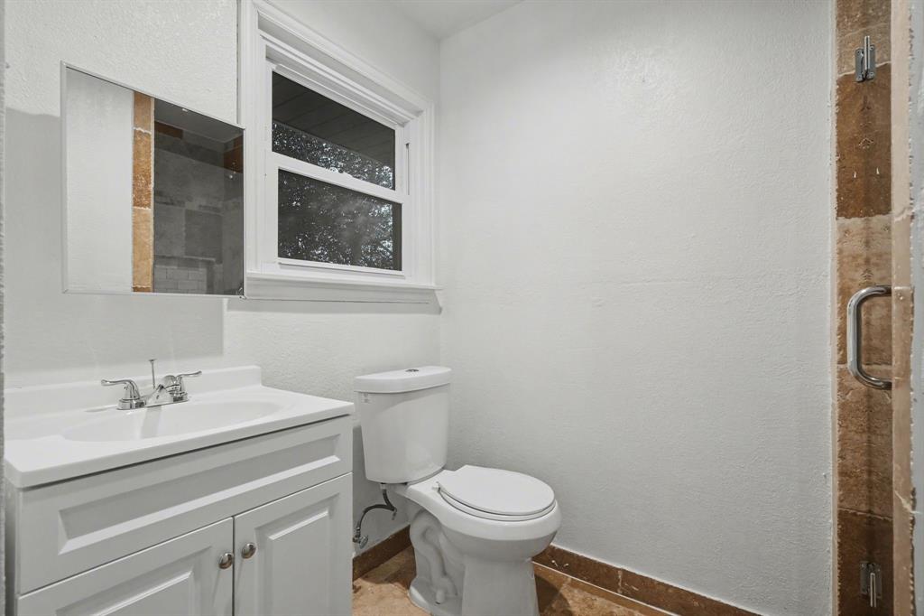 1714 East Union Bower Road Irving, TX 75061 - Photo 20 of 32 a bathroom with a toilet sink and mirror