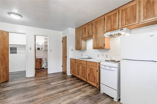 a kitchen with stainless steel appliances granite countertop a refrigerator a stove and a sink with cabinets