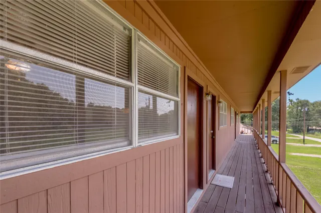 a view of a balcony with wooden floor and fence