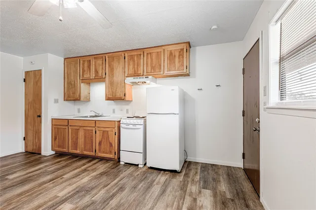 a view of a kitchen with wooden floor and electronic appliances