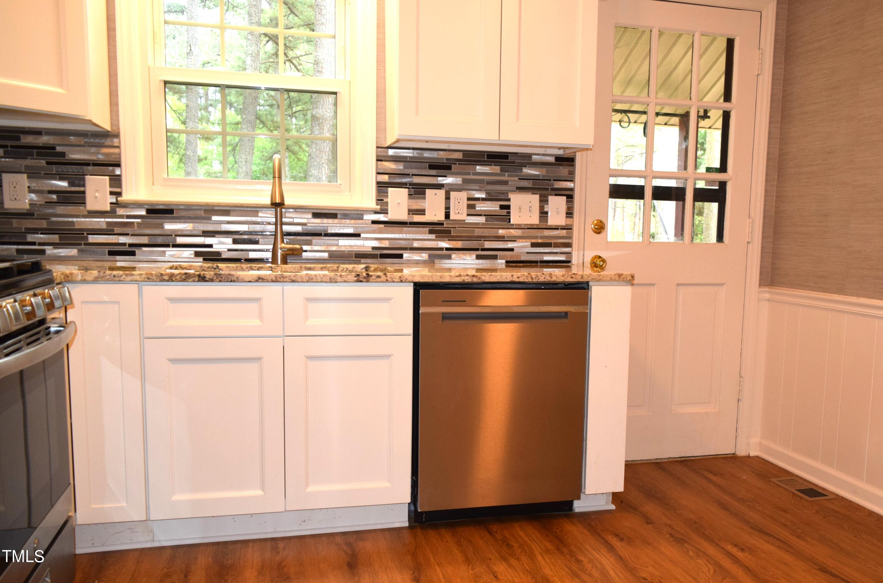2731 Umstead Road Durham, NC 27712 - Photo 8 of 22 a kitchen with stainless steel appliances granite countertop a stove a sink and a refrigerator
