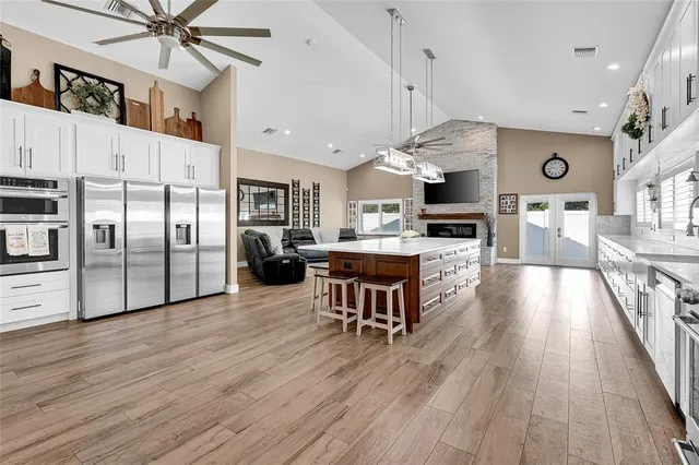 an open kitchen with wooden floor and stainless steel appliances