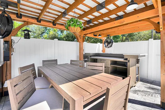 a living room with stainless steel appliances kitchen island granite countertop a refrigerator a stove a microwave oven a dining table and chairs with wooden floor