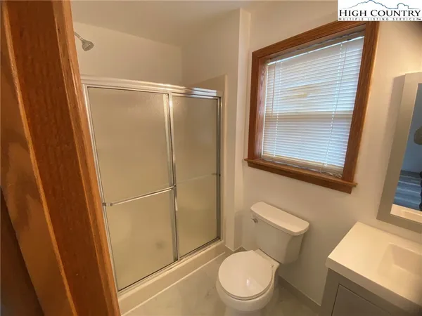 a bathroom with a sink and mirror with toilet