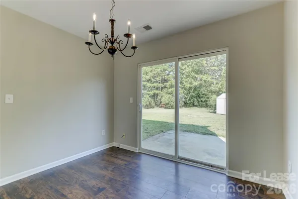 a view of a room with wooden floor and chandelier
