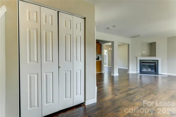 a view of empty room with wooden floor and a window