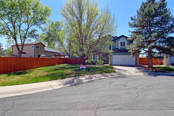 a front view of a house with a yard and tree s