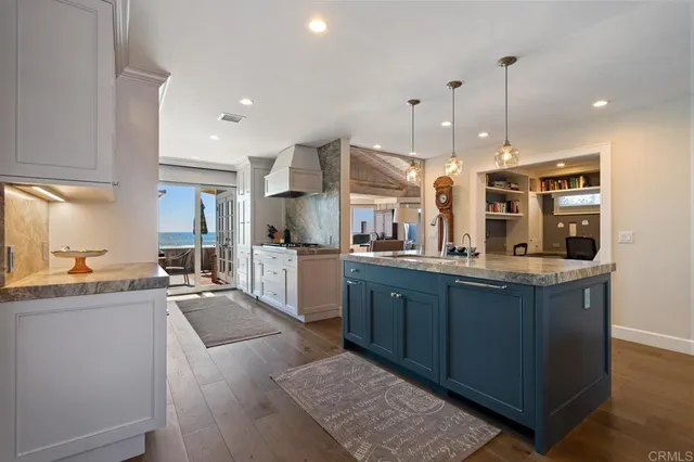 a kitchen with stainless steel appliances granite countertop a sink a stove and a wooden floors