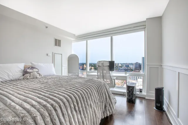 a bedroom with a bed and a large window