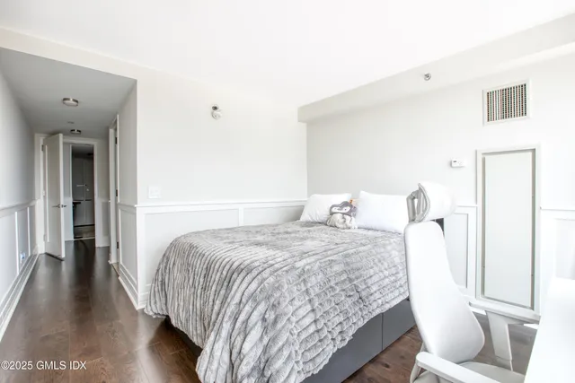 a bedroom with a bed and a wooden floor