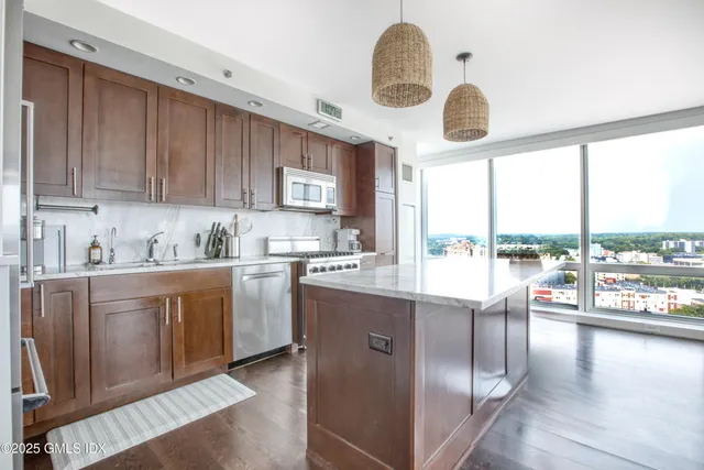 a kitchen with stainless steel appliances granite countertop a stove a sink and a refrigerator