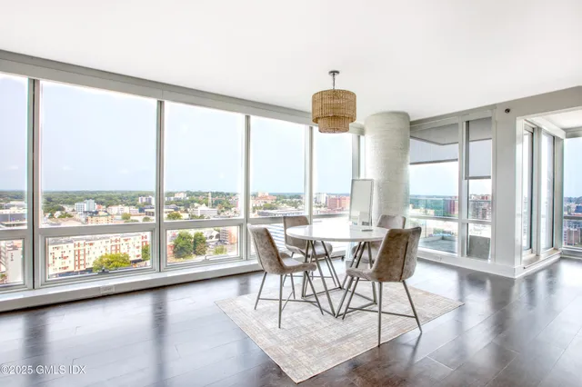 a dining room with furniture water view and large windows