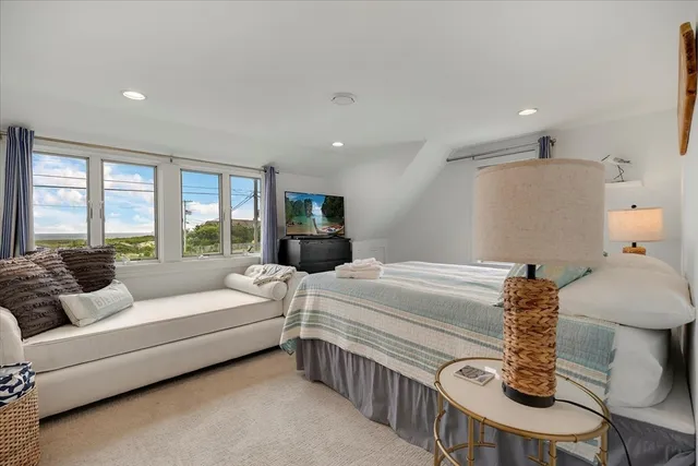 a bedroom with furniture and a large window