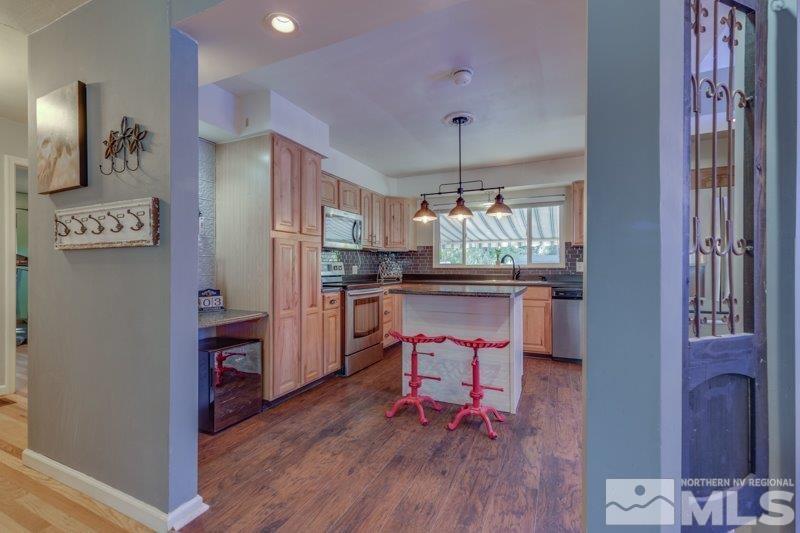 710 West 12th Street Reno, NV 89503 - Photo 10 of 25 a kitchen with stainless steel appliances granite countertop a refrigerator and a wooden floor