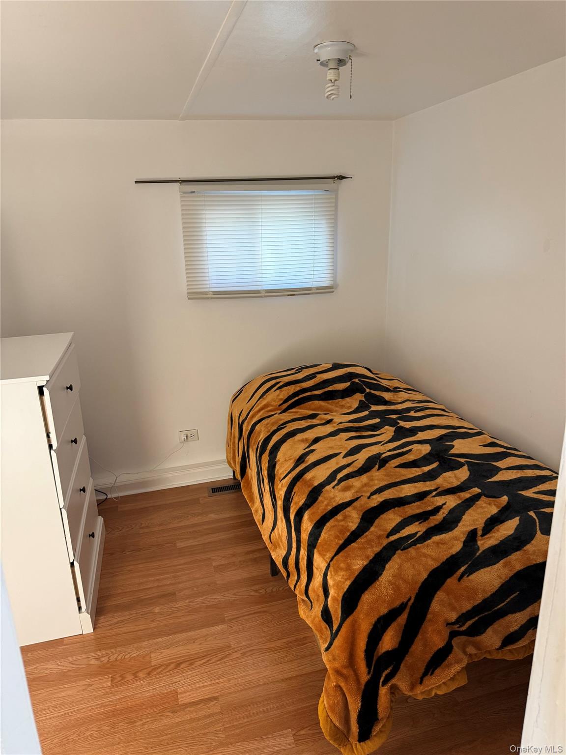136 Quaker Rd Park Pomona, NY 10970 - Photo 21 of 24 Bedroom 2 featuring wood-finish flooring, a single window with horizontal blinds, and a flush-mount ceiling light fixture