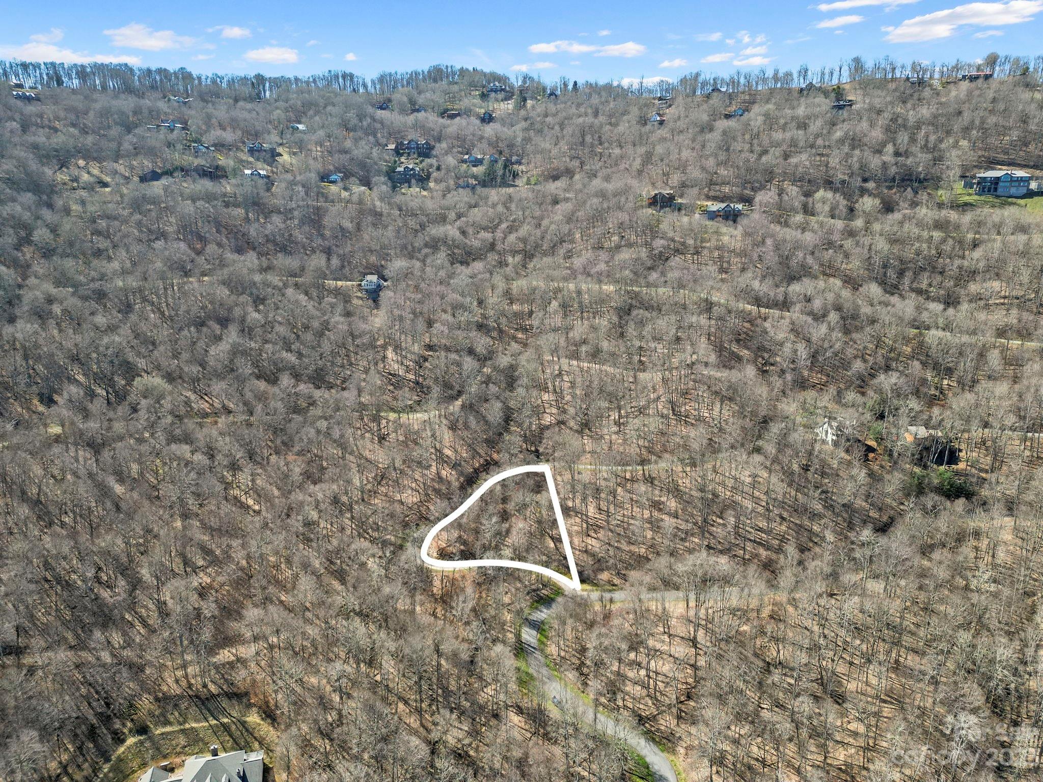 an aerial view of a house with a yard and mountain view in back