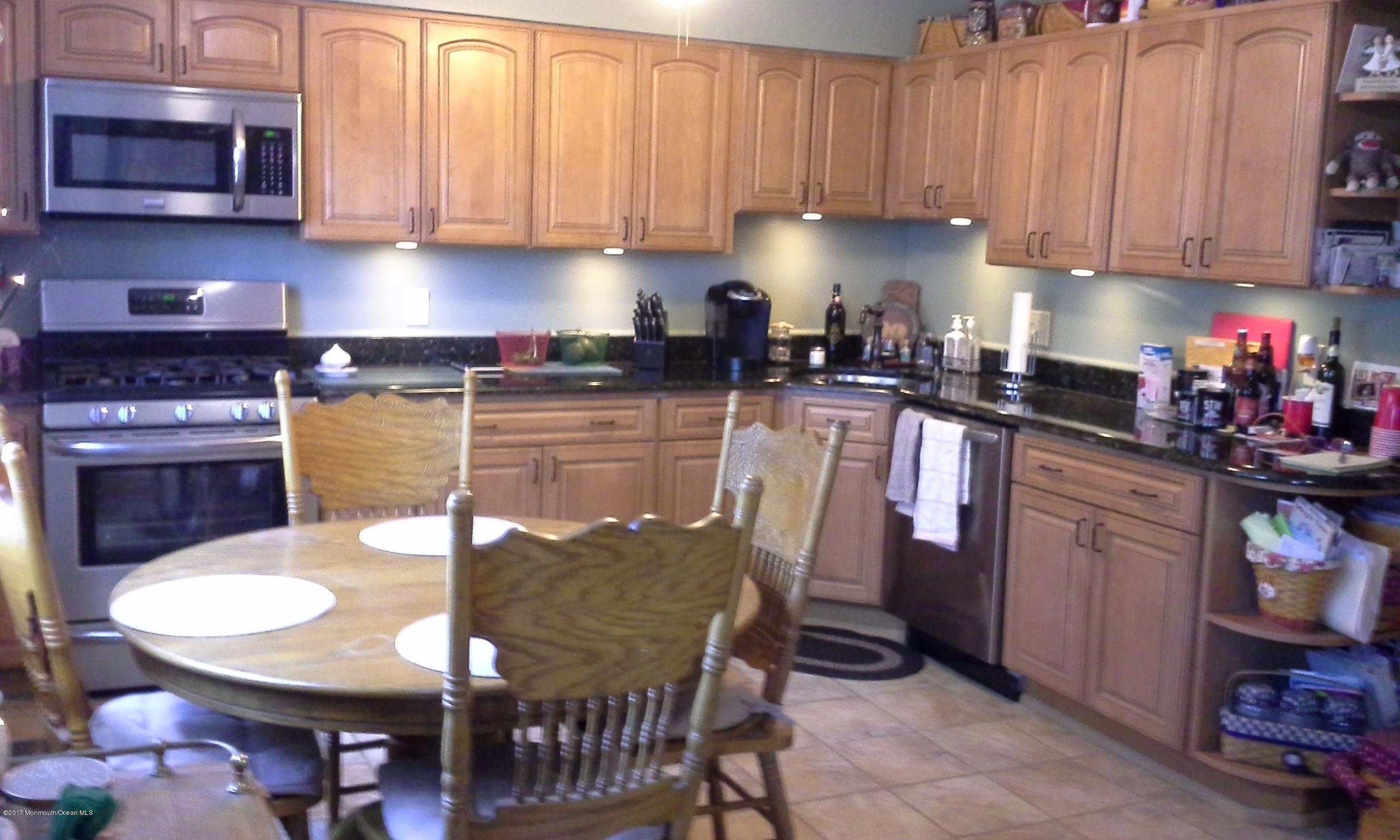 478 Rena Court Brick, NJ 08724 - Photo 3 of 13 a kitchen with stainless steel appliances granite countertop a stove top oven a sink a dining table and chairs