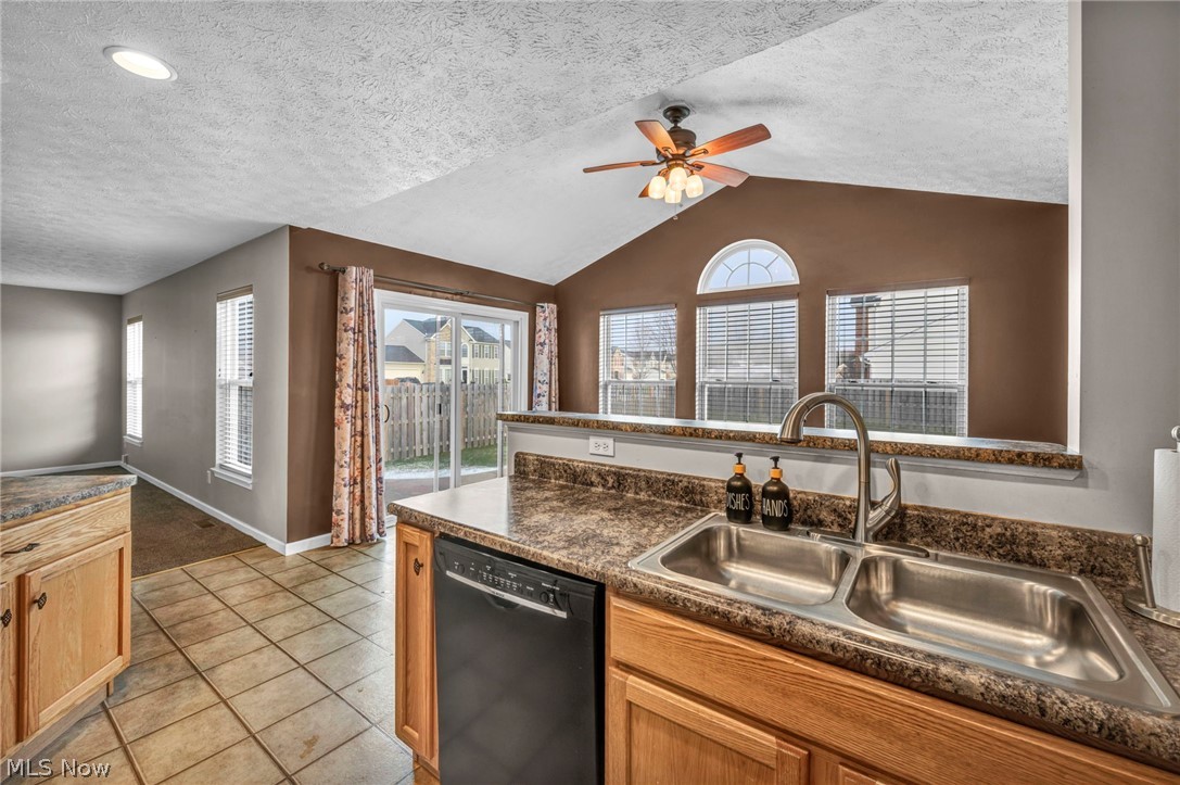 147 Stone Ridge Way Berea, OH 44017 - Photo 15 of 44 Kitchen featuring dark countertops, dishwasher, ceiling fan, and light tile patterned flooring