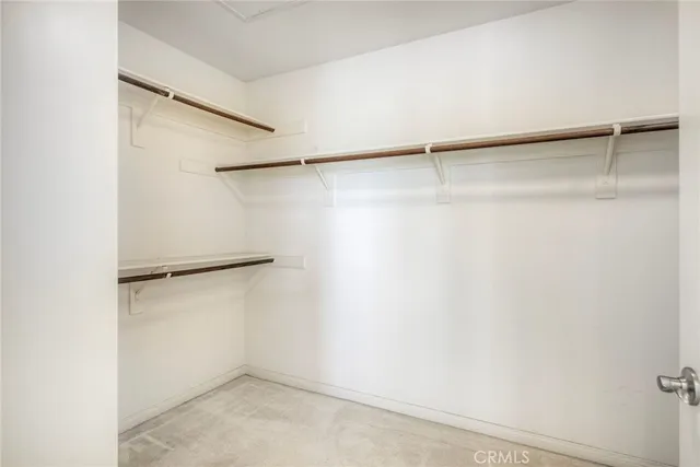 a view of walk in closet with empty racks