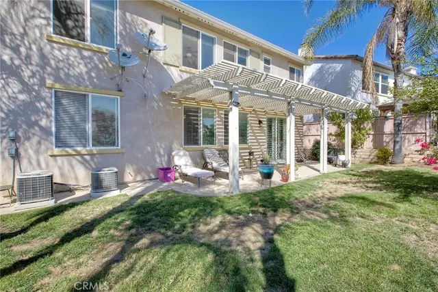 a front view of a brick house with a yard table and chairs