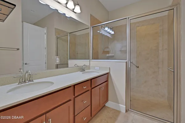 a bathroom with a double vanity sink mirror and shower