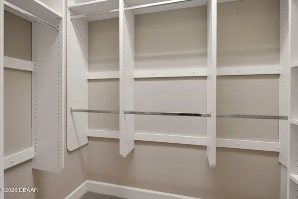 a view of walk in closet with empty racks