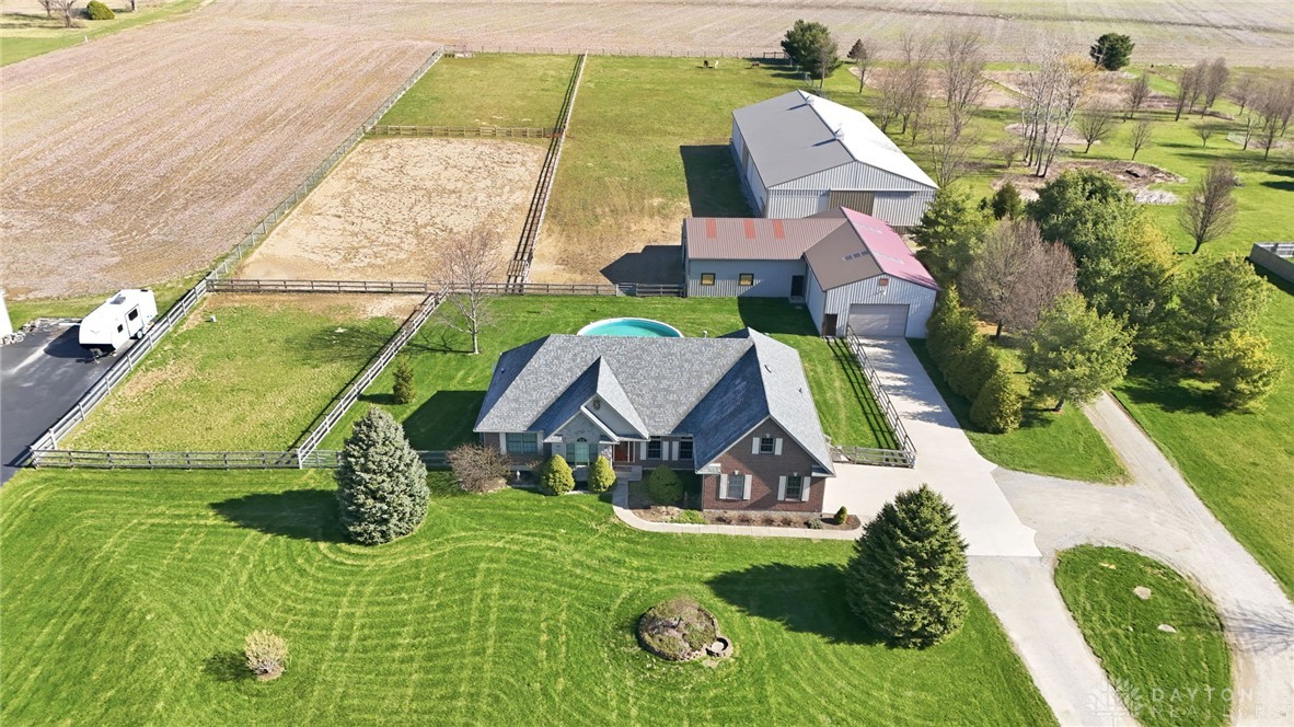 This spacious property features a charming home, lush greenery, and ample room for outdoor activities.