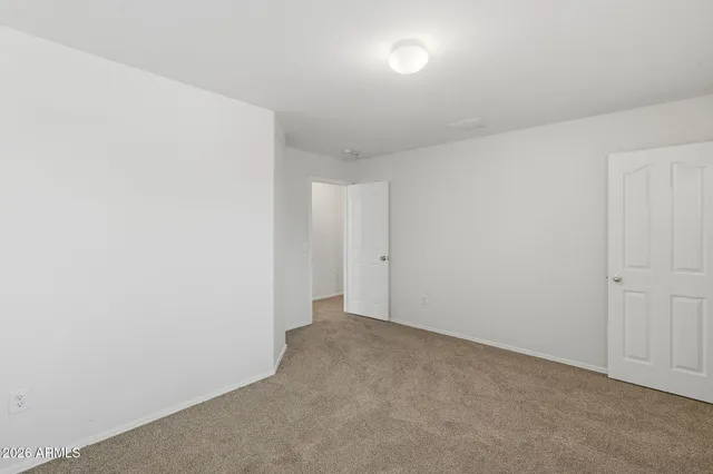 an empty room with chandelier fan and windows