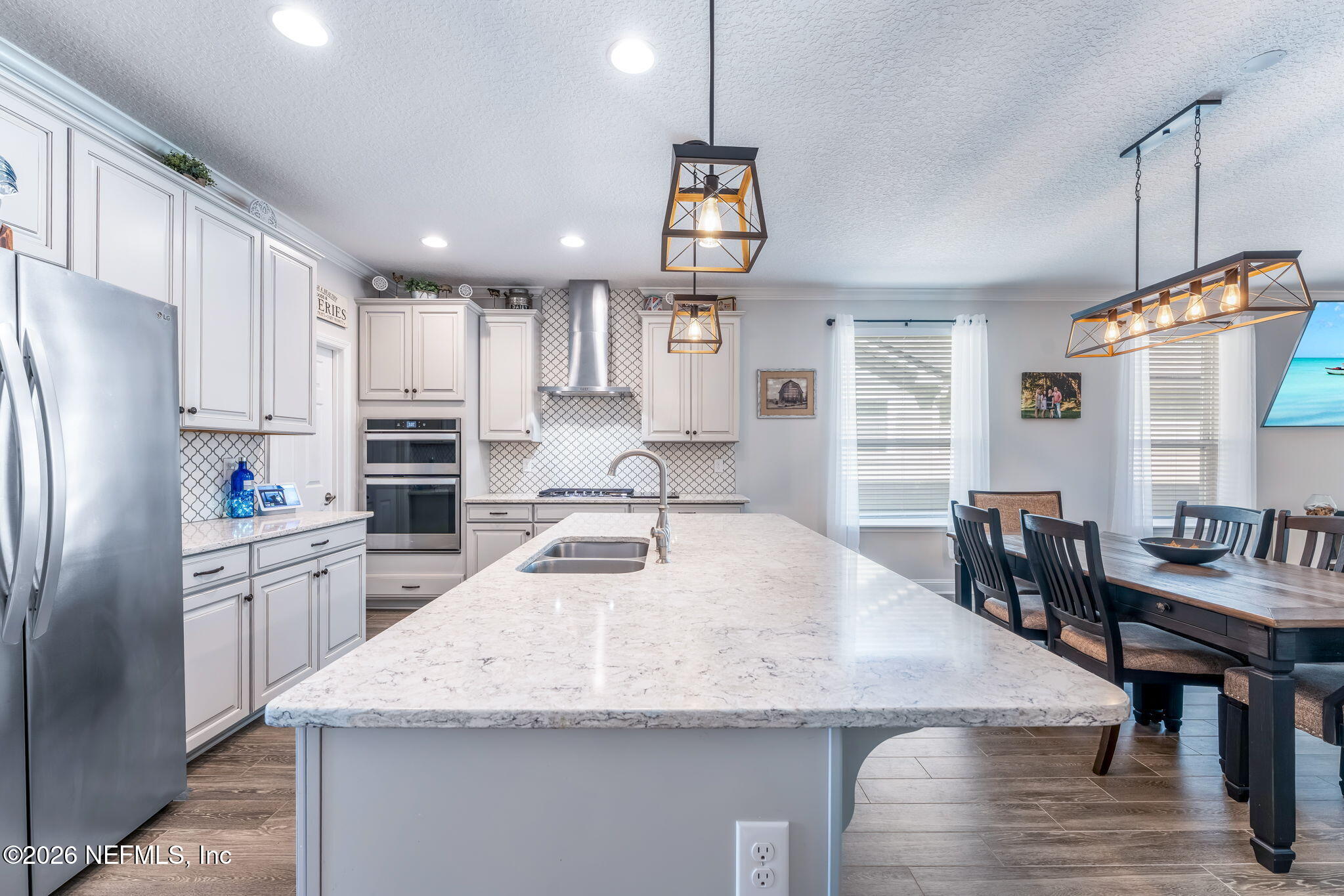 175 Convex Lane St. Augustine, FL 32095 - Photo 14 of 66 a kitchen with stainless steel appliances granite countertop a refrigerator a sink dishwasher a stove and white cabinets with wooden floor