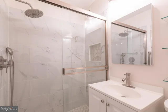 a bathroom with a sink mirror and shower