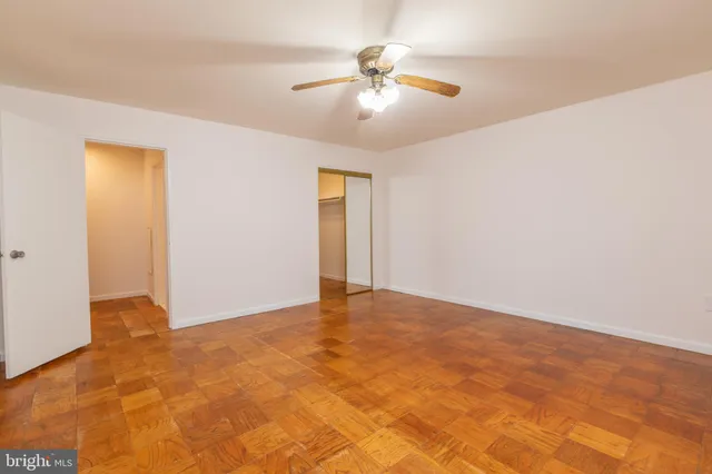 a view of an empty room with chandelier fan