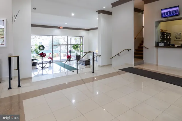 a living room with furniture a large window and storage