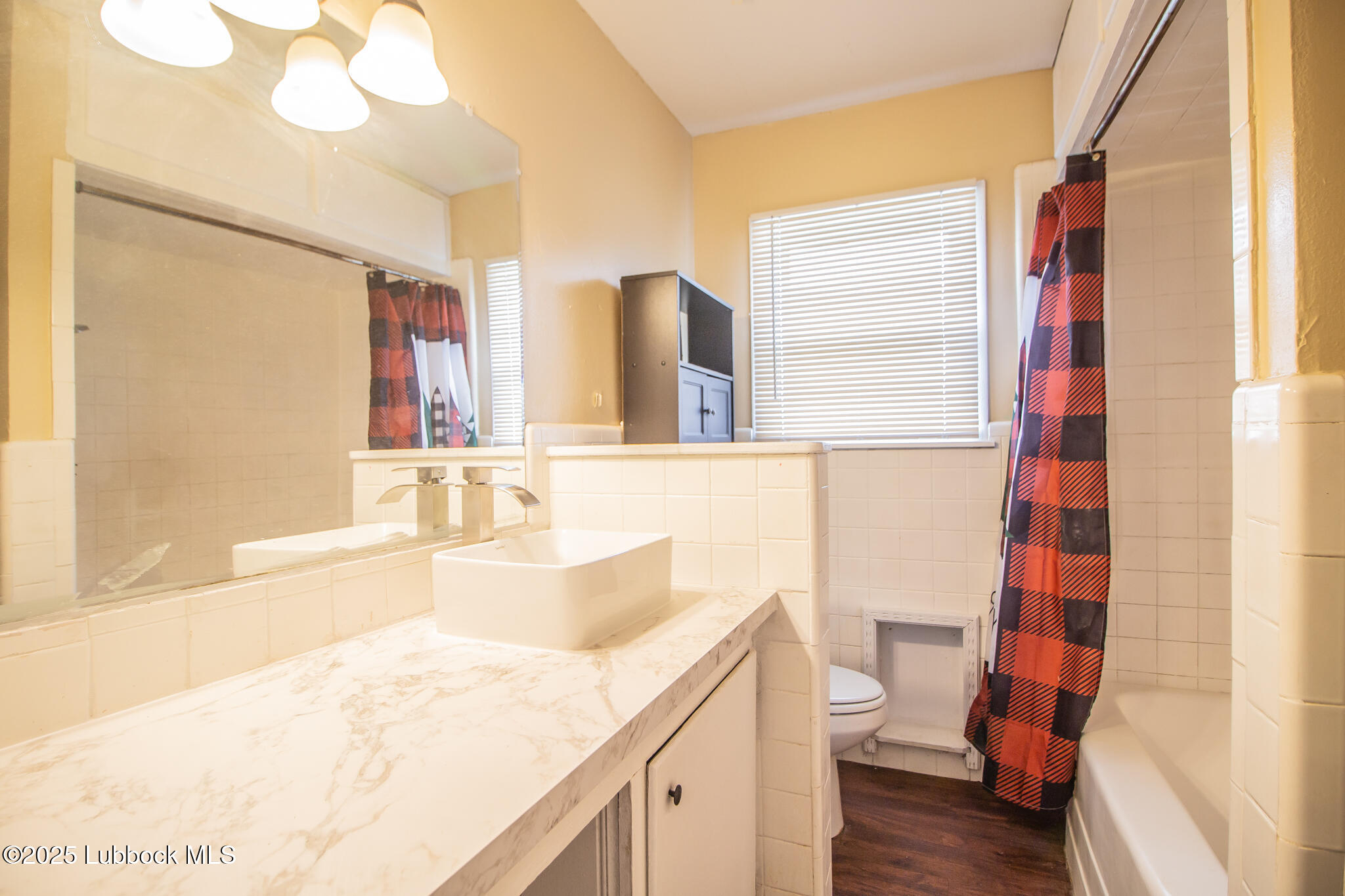 2414 38th Street Lubbock, TX 79412 - Photo 15 of 20 a bathroom with a sink a toilet and shower