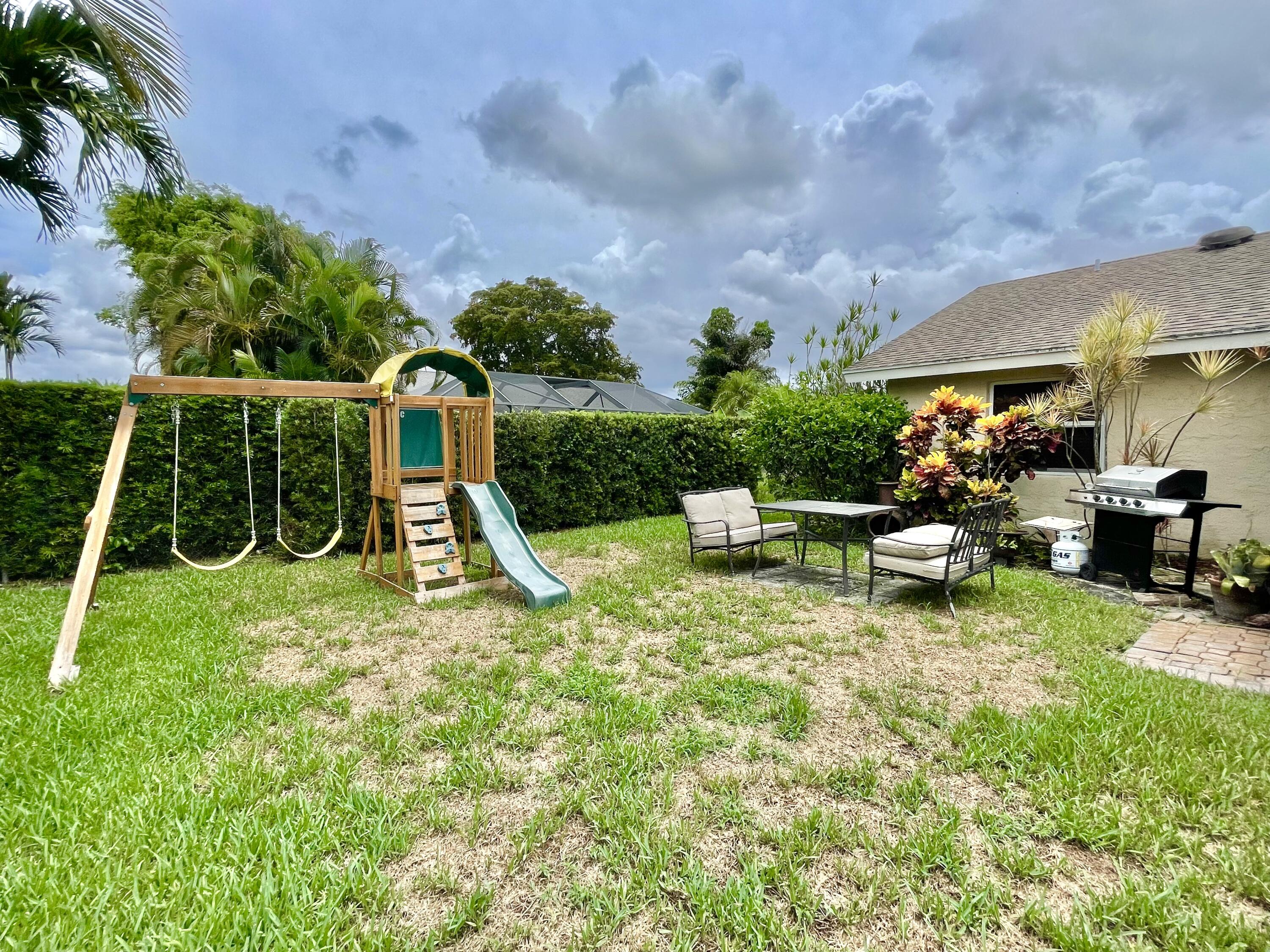 9505 Ohio Place Boca Raton, FL 33434 - Photo 4 of 44 a view of a backyard with couches chair and a fire pit