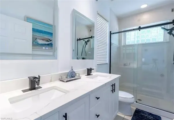 a bedroom with a bed lamp and a large window