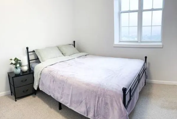a bedroom with a bed and a window