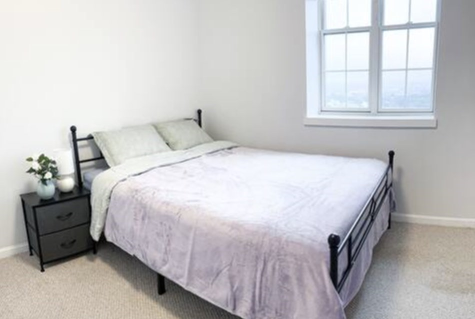 1505 Commonwealth Avenue, Unit 403 Boston, MA 02135 - Photo 11 of 16 a bedroom with a bed and a window