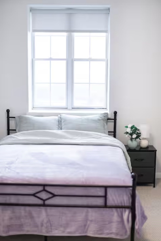 1505 Commonwealth Avenue, Unit 403 Boston, MA 02135 - Photo 12 of 16 a bedroom with a bed and window