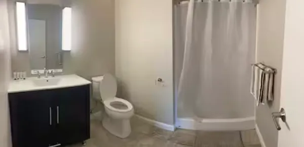 a bathroom with a sink a toilet and shower