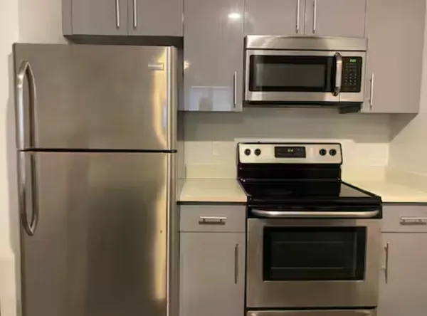 a white refrigerator freezer and a stove sitting inside of a kitchen