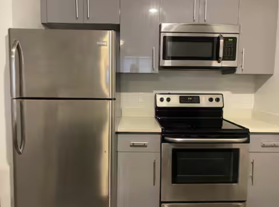 1505 Commonwealth Avenue, Unit 403 Boston, MA 02135 - Photo 2 of 16 a white refrigerator freezer and a stove sitting inside of a kitchen
