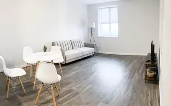 a living room with furniture and a wooden floor