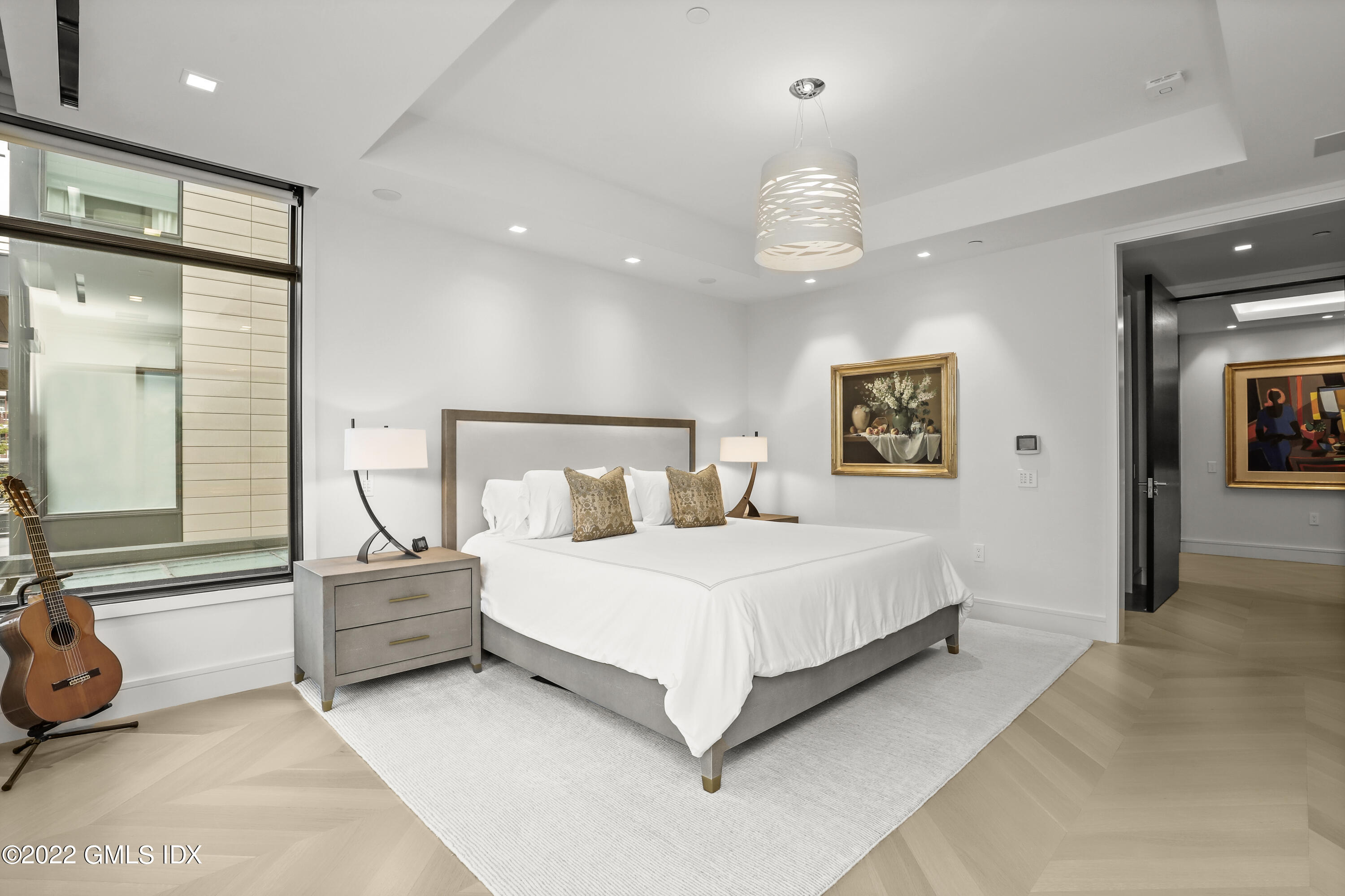 125 Field Point Road, Unit A4 Greenwich, CT 06830 - Photo 13 of 33 a bedroom with a large bed and a chandelier