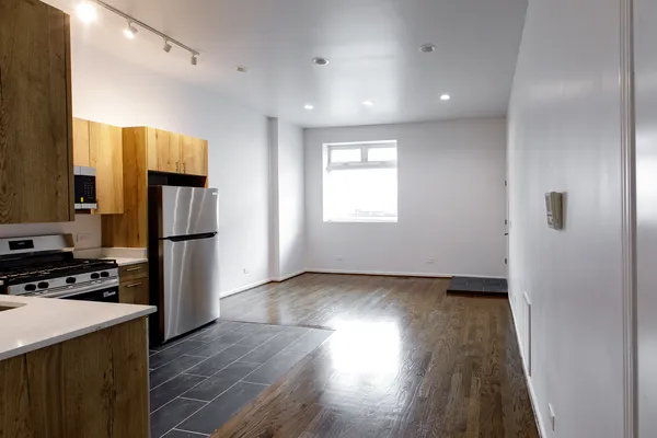 a view of a kitchen with refrigerator and wooden floor